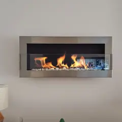 Nowoczesny biokominek wiszący z szybą, w którym tańczą płomienie, dodaje ciepła i stylu wnętrzu.