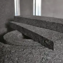 Czarne, porowate materiały izolacyjne, idealne do tego, jak wyciszyć okna, leżą obok metalowych profili.