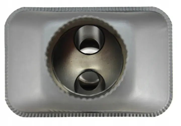 Metalowy radiator do kominka, z dwoma okrągłymi otworami w środku, gotowy do montażu.